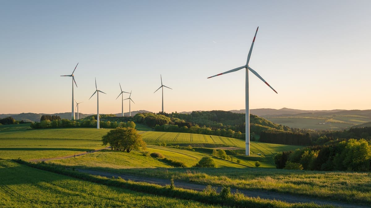 Image of wind turbines over a sunset fieldscape.